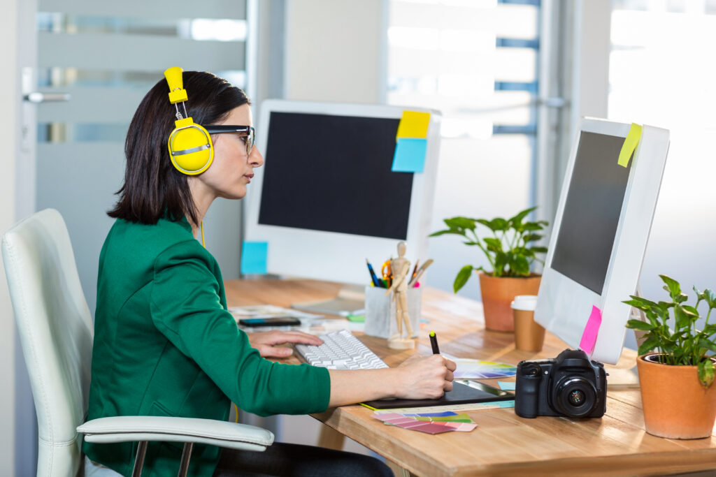 Individual using headphones while working, promoting workplace wellbeing and concentration